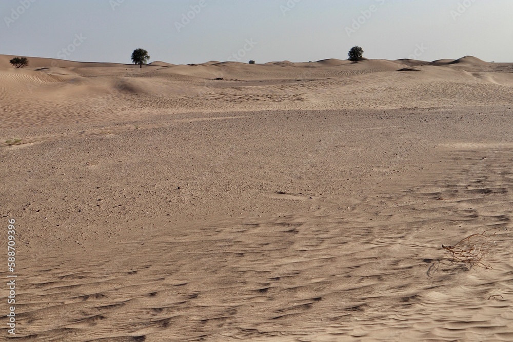 Scenic view of desert against sky under the clear blue sky with the sun shining bright Scenic view of desert against sky under the clear blue sky with the sun shining bright