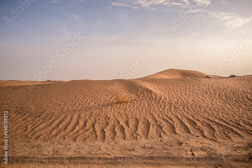 Landscape view of sandy desert dunes with purple sunset sky