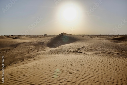 Fototapeta Naklejka Na Ścianę i Meble -  Sand dunes in a desert with a sunlight in the background