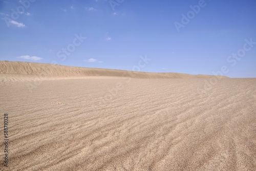 Sand in the dry desert on a sunny day against a blue sky