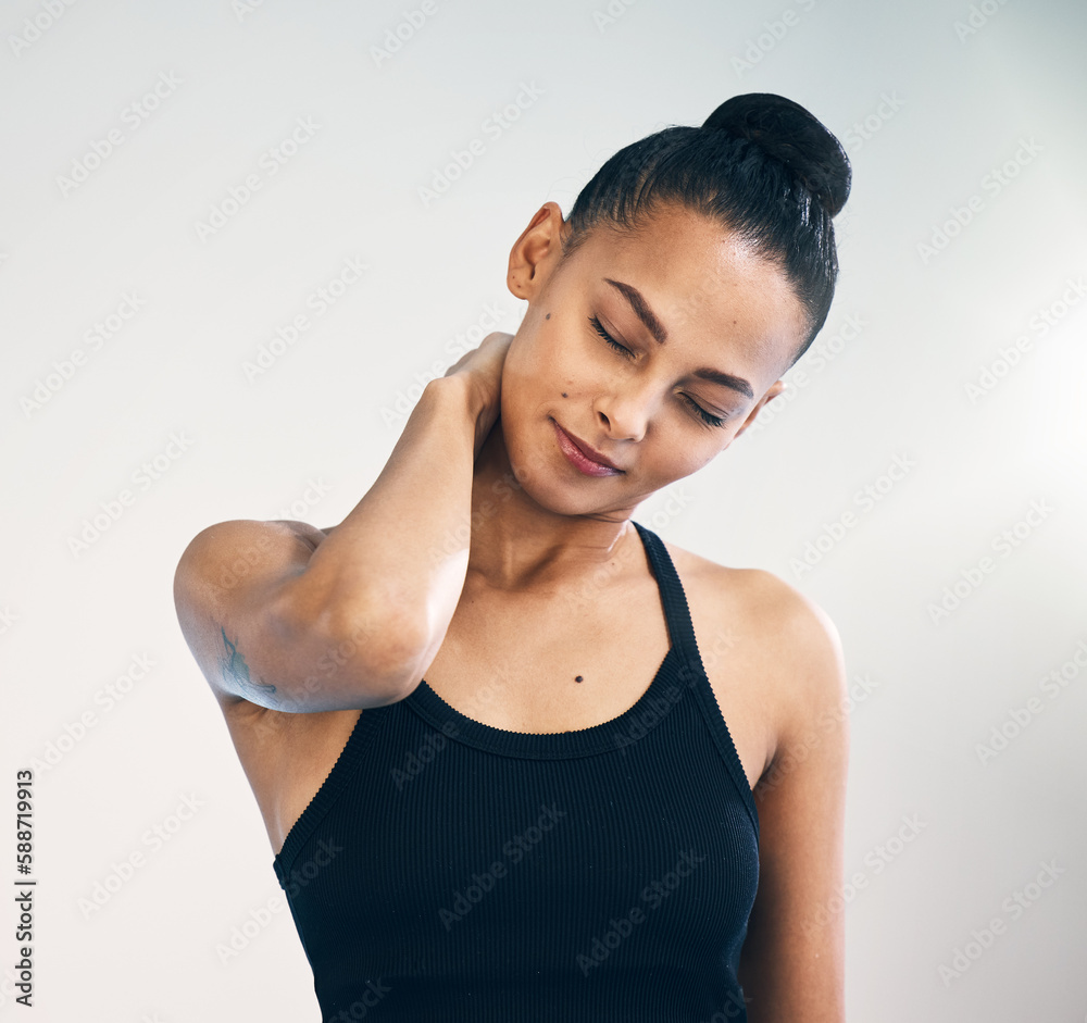 Fitness, injury and woman with neck pain in studio during yoga routine against grey background. Spine, problem and girl suffering from injured muscle, arthritis or shoulder strain after workout run Fitness, injury and woman with neck pain in studio during yoga routine against grey background. Spine, problem and girl suffering from injured muscle, arthritis or shoulder strain after workout run