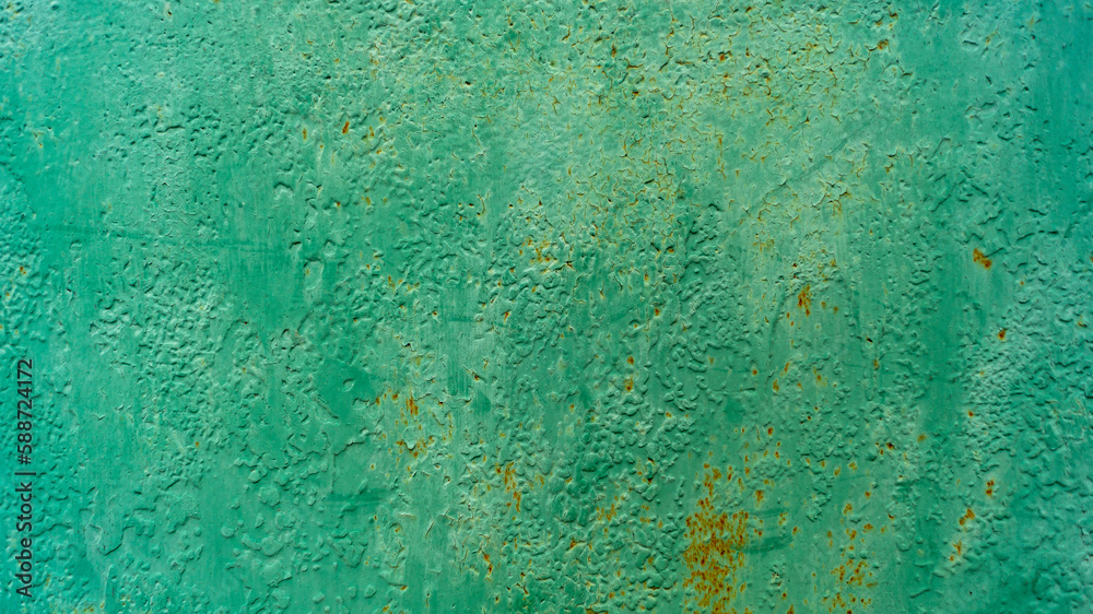 Green paint on a rusting surface. Green paint and rust. The paint is peeling. Green background with cracks