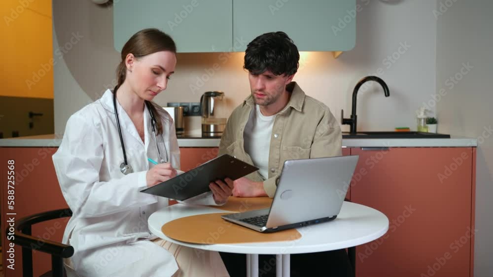 The concept of medicine, healthcare and people is a happy smiling female doctor showing an X-ray to a male patient in his kitchen.