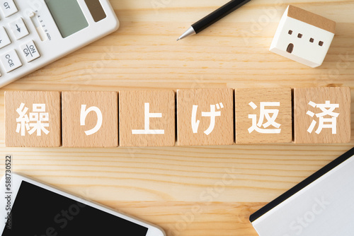 繰り上げ返済と書かれたブロック、電卓、スマホ、家のオブジェ、ノート