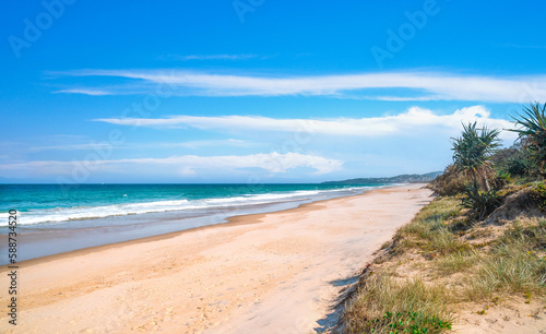 Fototapeta Naklejka Na Ścianę i Meble -  Stunning panoramic view of the ocean and beautiful waves rolling in on a pristine sandy beach.  