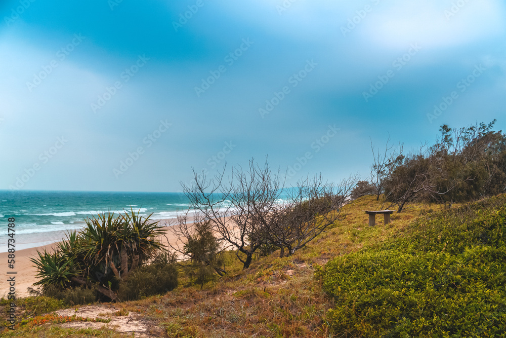 Spectacular panoramic view of the Peregian beach with Pacific ocean waves crushing on the shore visible from the green hill on a bright sunny day on Sunshine Coast, Queensland, Australia. Spectacular panoramic view of the Peregian beach with Pacific ocean waves crushing on the shore visible from the green hill on a bright sunny day on Sunshine Coast, Queensland, Australia.