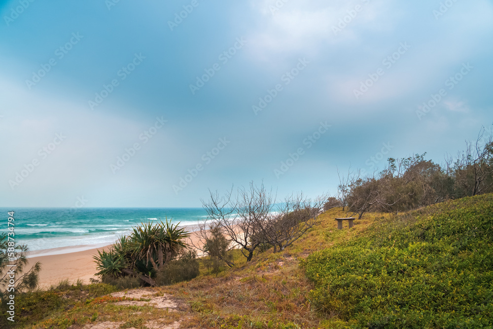 Spectacular panoramic view of the Peregian beach with Pacific ocean waves crushing on the shore visible from the green hill on a bright sunny day on Sunshine Coast, Queensland, Australia.