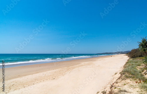 Stunning panoramic view of the Peregian beach with Pacific ocean waves crushing on the shore on a bright sunny day on Sunshine Coast, Queensland, Australia.