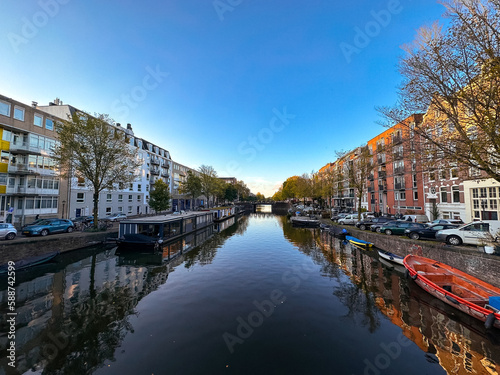 Amsterdam canal view with boats and bicycles at sunset, Netherlands © pierrick