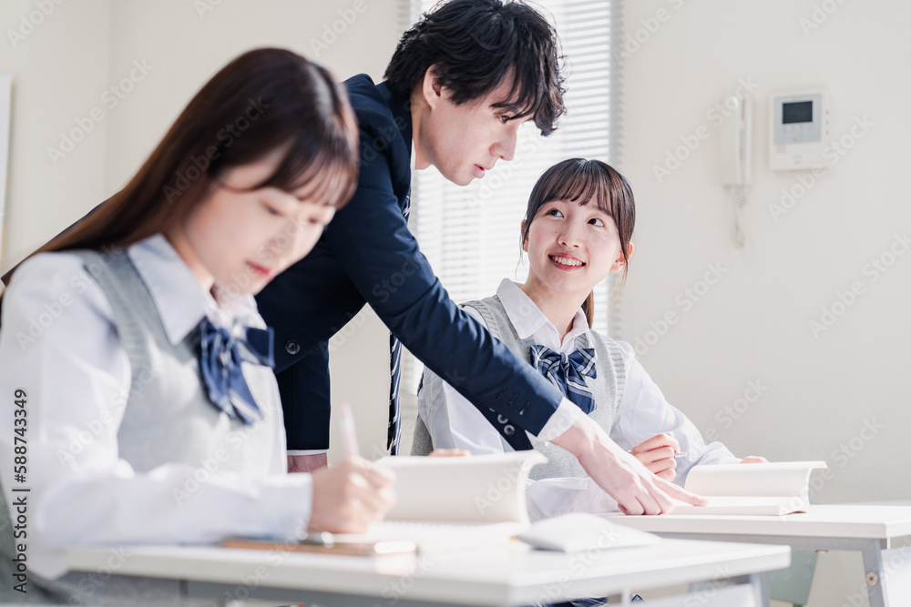 教室で先生に質問をする高校生 教室で先生に質問をする高校生