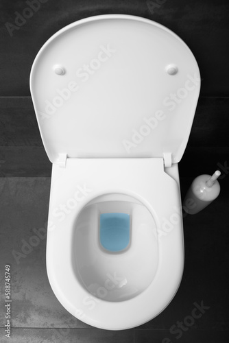 White toilet bowl with raised lid top view.