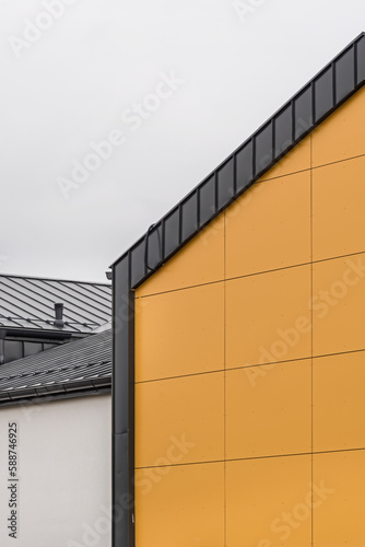Kolorowa elewacja obiektu, budynku. Materiał z pionowych pomarańczowych paneli. 