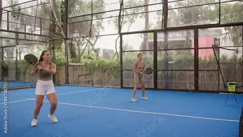 People play tennis outdoor court. Young adult player serve ball opponent. Racket sport game match. Athlete team hit workout outside arena. Sportsman health care. Woman person fit exercise. Girl trains