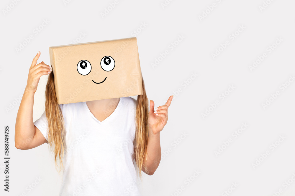 Mujer con caja de cartón en la cabeza y con un gesto con los dedos de la mano señalando hacia arriba sobre fondo gris claro liso y aislado. Vista de frente y de cerca. Copy space
 - obrazy, fototapety, plakaty 