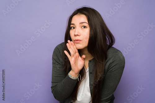 Quadro su tela Secretive woman sharing a secret or gossip