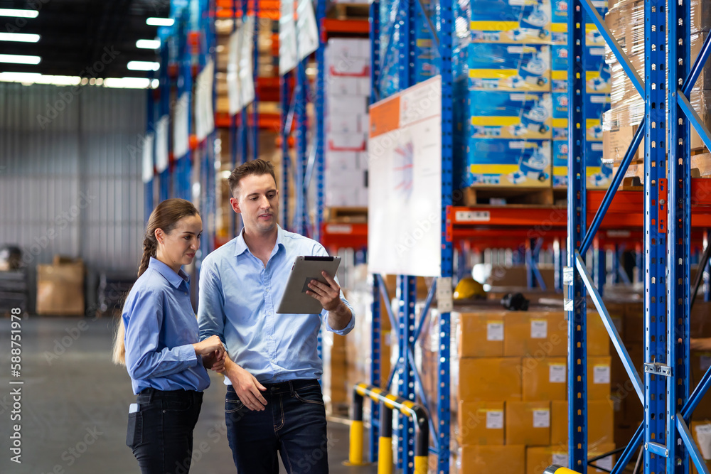 Caucasian team man and woman worker working at warehouse factory. Warehouse staff worker standing by goods shelf working in large warehouse Caucasian team man and woman worker working at warehouse factory. Warehouse staff worker standing by goods shelf working in large warehouse