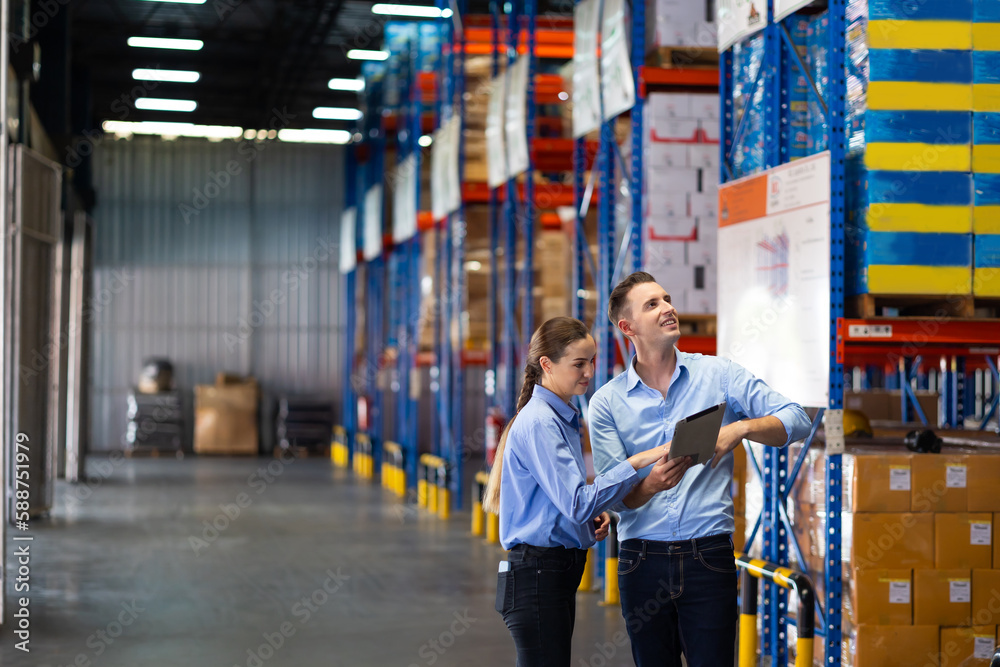 Caucasian team man and woman worker working at warehouse factory. Warehouse staff worker standing by goods shelf working in large warehouse Caucasian team man and woman worker working at warehouse factory. Warehouse staff worker standing by goods shelf working in large warehouse