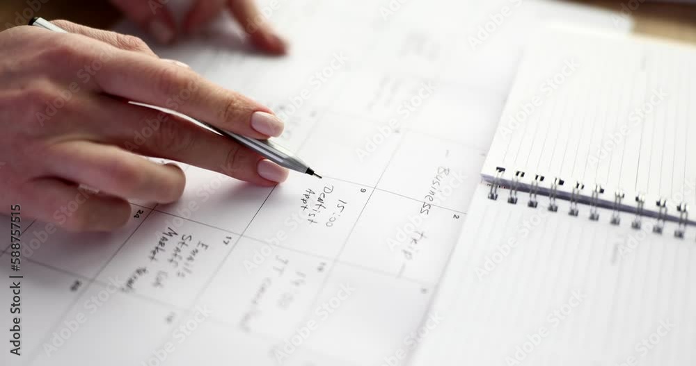 Businesswoman with pen in hands reads notes on calendar. Purposeful business woman managing tasks in planner