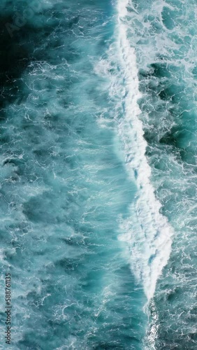 Ocean waves breaking and foaming. Aerial vertical video background