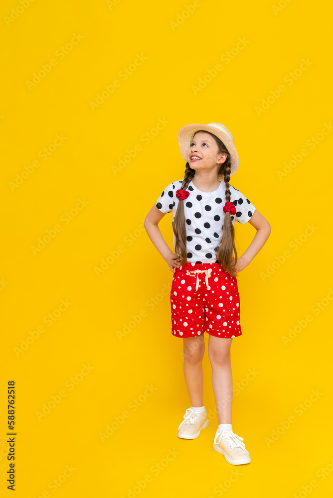 An attractive young teenage girl in a straw hat and summer clothes, a girl in a white T-shirt and red shorts on an isolated background, a space for copying. The concept of summer holidays. An attractive young teenage girl in a straw hat and summer clothes, a girl in a white T-shirt and red shorts on an isolated background, a space for copying. The concept of summer holidays.