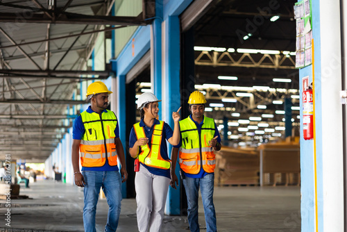 Group of three warehouse asian indian workers wearing safety hardhats helmet inspection in container at warehouse. E-Commerce Goods at Logistics Warehouse factory.warehouse interior with shelves