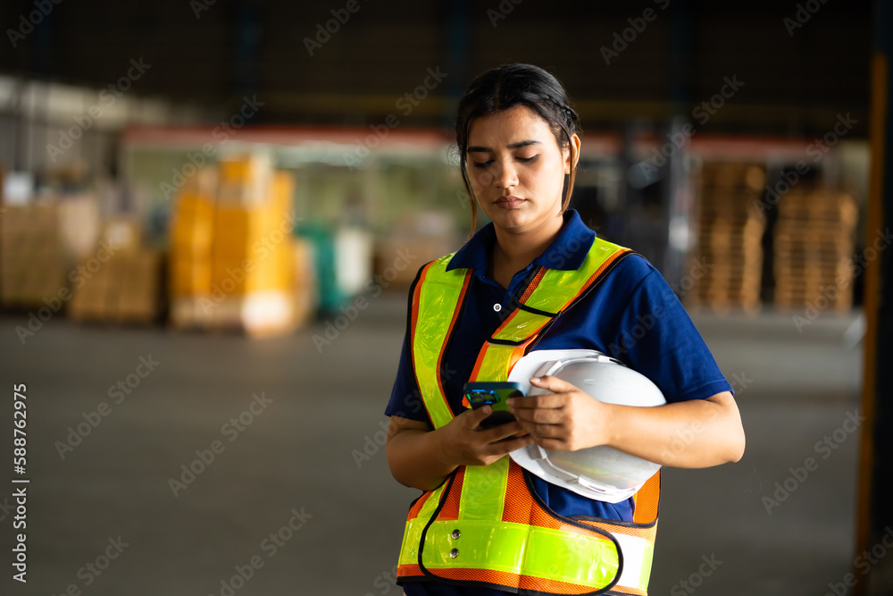 Use mobile phone. Portrait warehouse indian female worker wearing