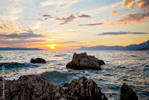 Amazing beach sunset with endless horizon and incredible foamy waves.