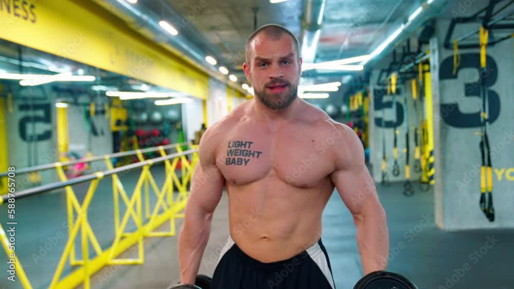 Bald bodybuilder exercising in the gym. Raises the barbell, dumbbells, jumping rope, trx workout. Pumped up big muscles. Work with large, heavy weights in the gym. Nice curvy body. Bald bodybuilder exercising in the gym. Raises the barbell, dumbbells, jumping rope, trx workout. Pumped up big muscles. Work with large, heavy weights in the gym. Nice curvy body.