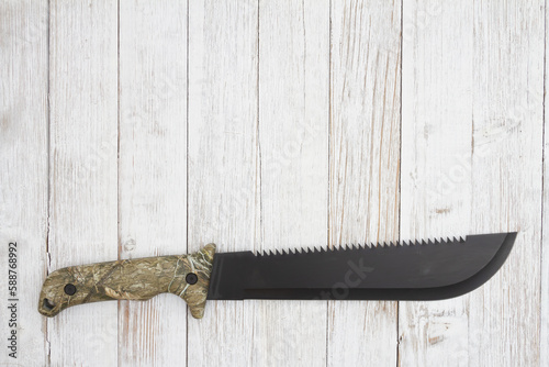 Camo machete background on weathered wood photo