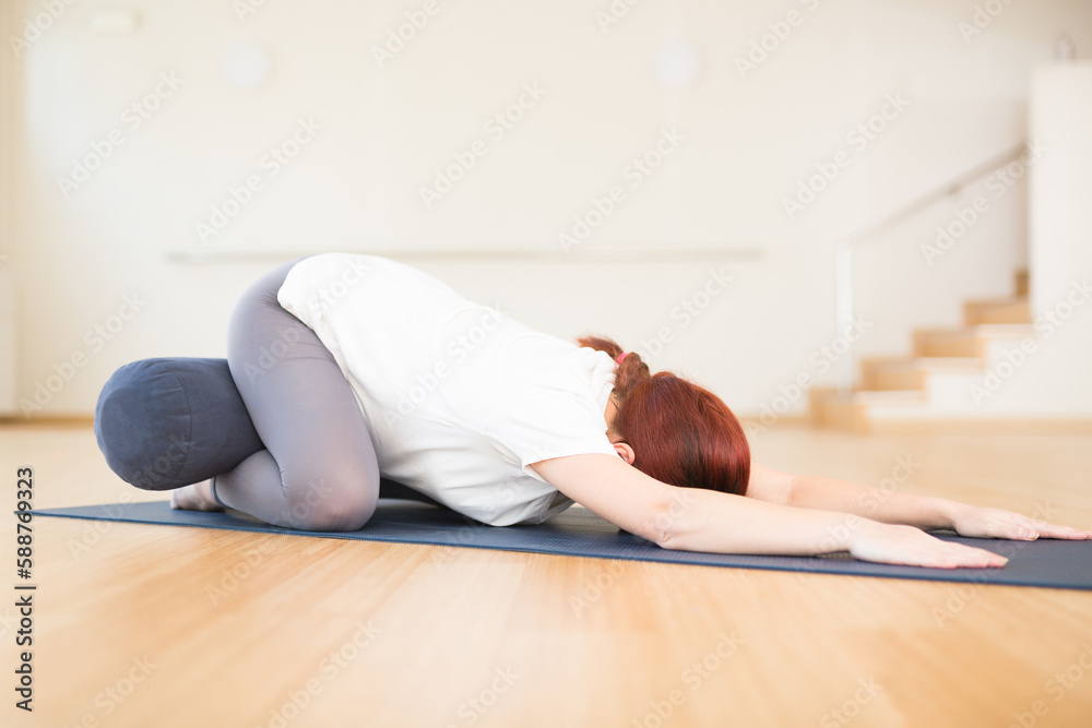 Fototapeta premium pregnant woman is engaged in yoga. Children asana with knees apart or Balasana