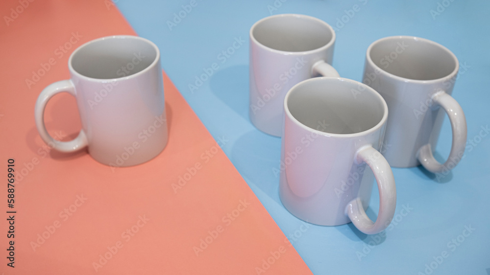 White mug on a blue and pink background. Minimalism. White mug on a blue and pink background. Minimalism.