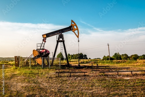 Oil and gas industry. Working oil pump jack on oil field at sunset