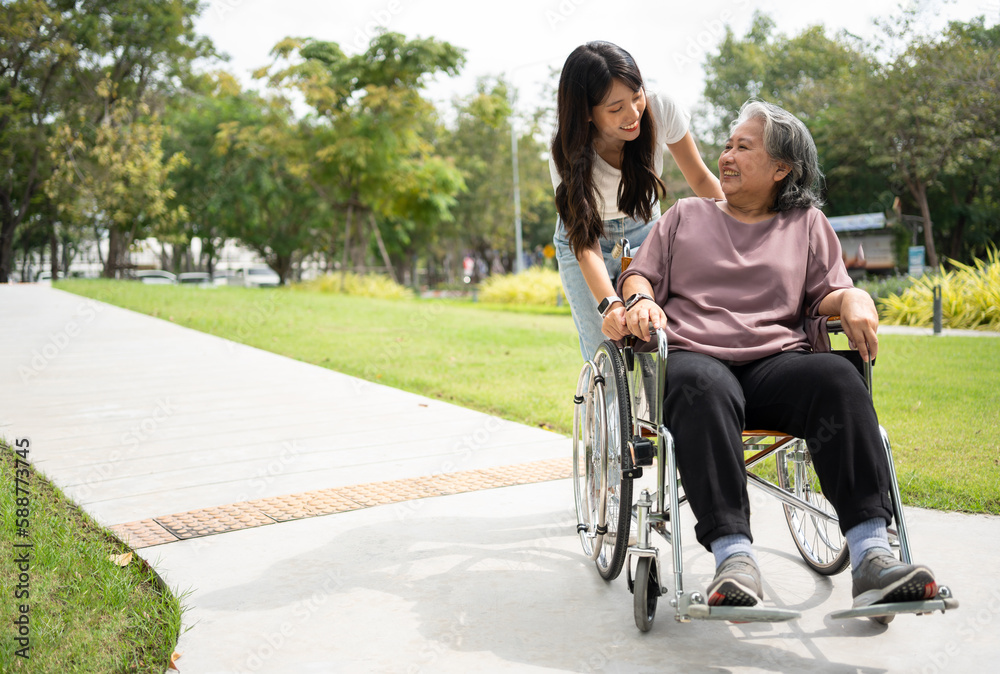 Asian careful caregiver or nurse taking care of the patient in a wheelchair. Concept of happy retirement with care from a caregiver and Savings and senior health insurance, a Happy family Asian careful caregiver or nurse taking care of the patient in a wheelchair. Concept of happy retirement with care from a caregiver and Savings and senior health insurance, a Happy family