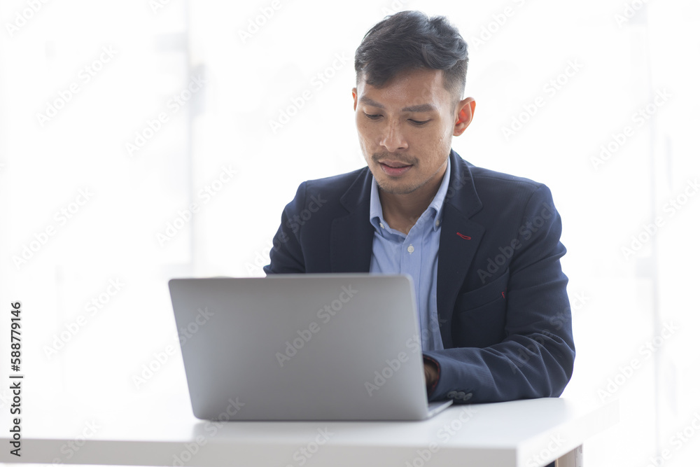 Handsome young business asian man using digital laptop at Busy elegant bearded adult company director, checking the company finances, at the office. Handsome young business asian man using digital laptop at Busy elegant bearded adult company director, checking the company finances, at the office.