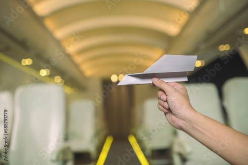 A paper airplane is being carried on an airplane in the cabin.