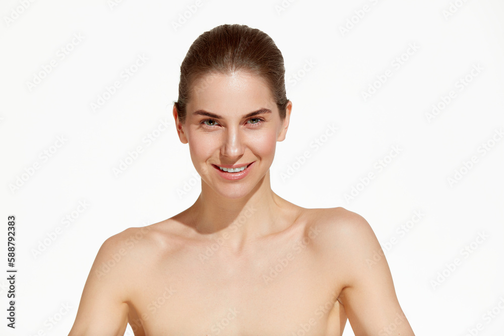 Portrait of beautiful woman with smooth skin with bare shoulders looking at camera over white background. Close up Portrait of beautiful woman with smooth skin with bare shoulders looking at camera over white background. Close up
