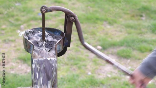 Old pump used to extract water from the field in Turkey. Retro well pump, old manual water pump (Lever pump). Vintage cast iron water pump. With handle for pumping 4K video shoot. photo