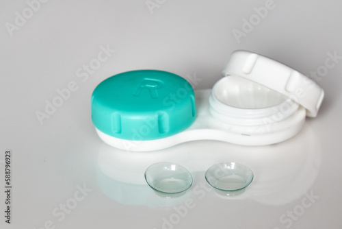 Contact lenses on the background of a container for them. The topic of medicine and health care. Up close