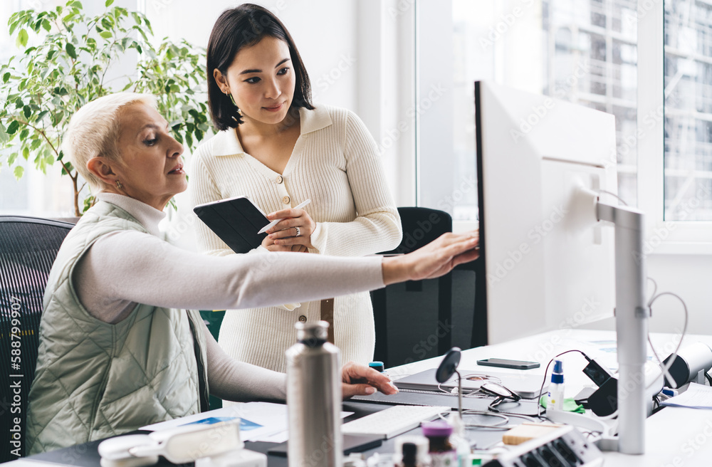 Multiracial colleagues working in office at table with computer