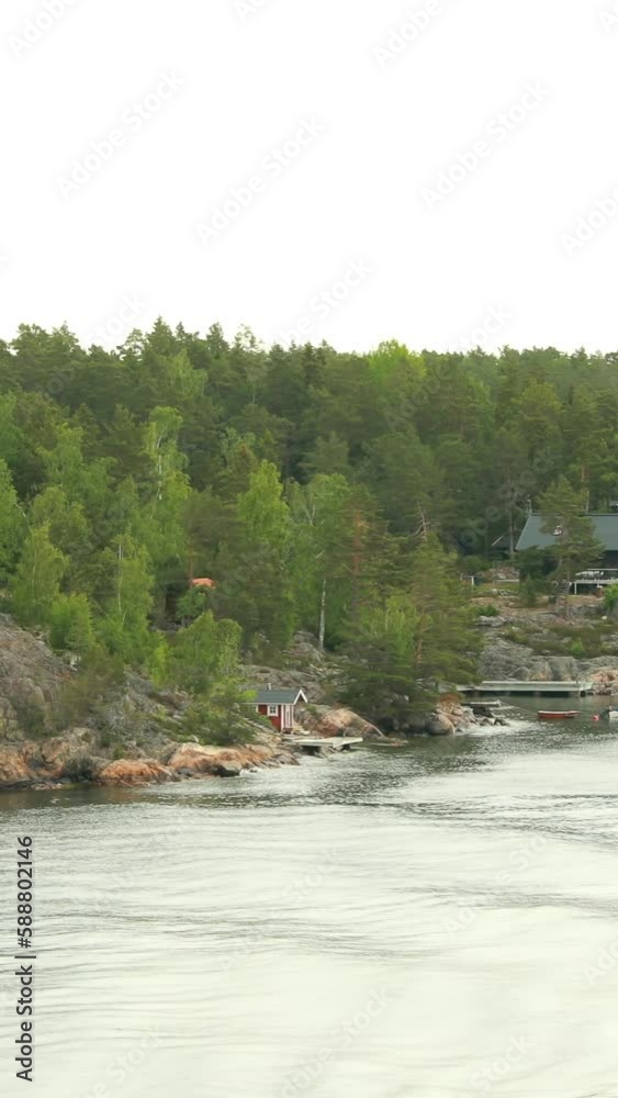 Many Swedish Wooden Sauna Logs Cabins Houses On Island Coast In Summer Cloudy Day. Vertical Footage Video. Many Swedish Wooden Sauna Logs Cabins Houses On Island Coast In Summer Cloudy Day. Vertical Footage Video.