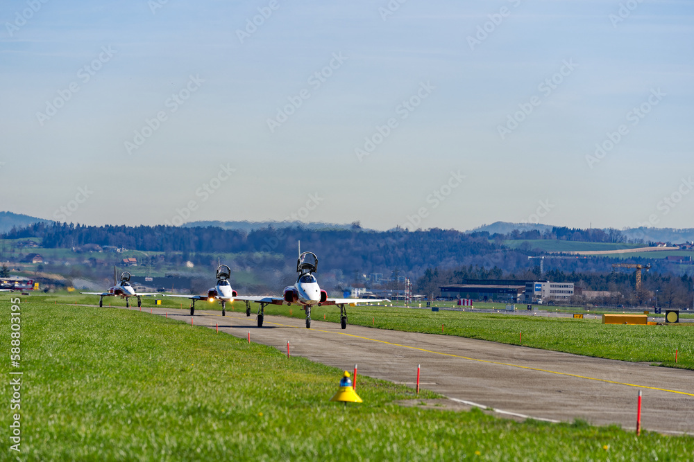 Fototapeta premium Fighters Northrop F-5E Tiger II of air display team Patrouille Swiss of Swiss Air Force taxiing to runway on a sunny spring day. Photo taken March 22nd, 2023, Emmen, Switzerland.