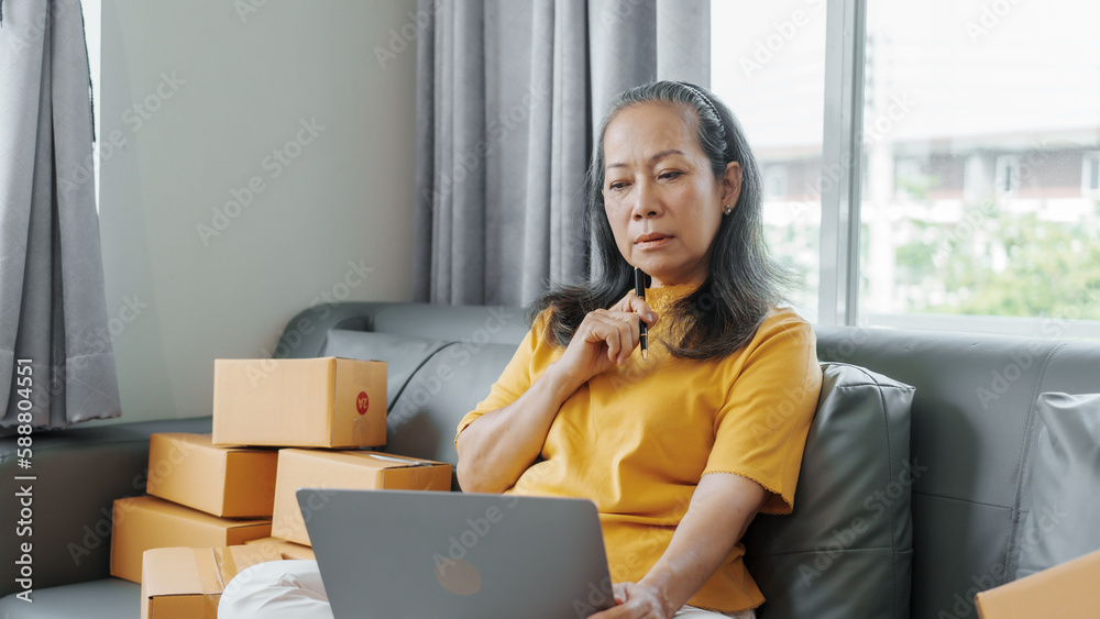 Successful asia people woman entrepreneur with parcel boxes checking email order in tablet and laptop at sofa home office SMEs small company. Successful asia people woman entrepreneur with parcel boxes checking email order in tablet and laptop at sofa home office SMEs small company.