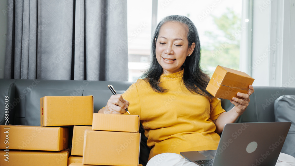 Successful asia people woman entrepreneur with parcel boxes checking email order in tablet and laptop at sofa home office SMEs small company. Successful asia people woman entrepreneur with parcel boxes checking email order in tablet and laptop at sofa home office SMEs small company.