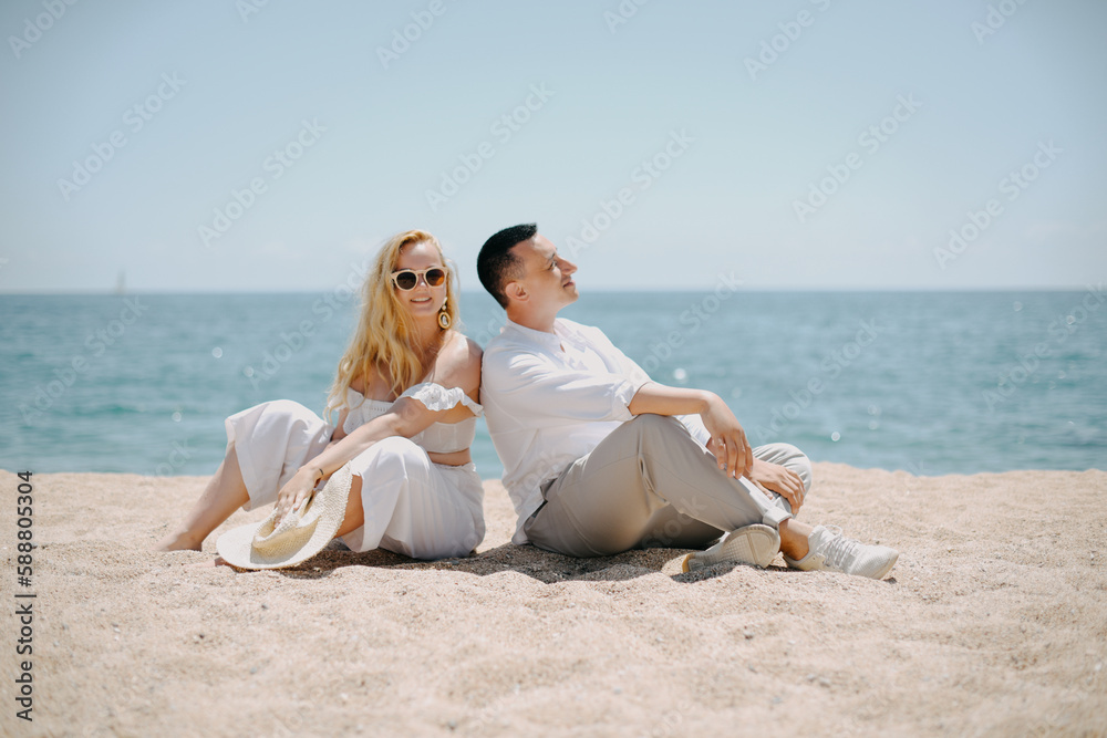 Lovers siting looking into sky and ocean, mountion, under sun.  Vacation, tourism, hooneymoon. Girl with a long hair.