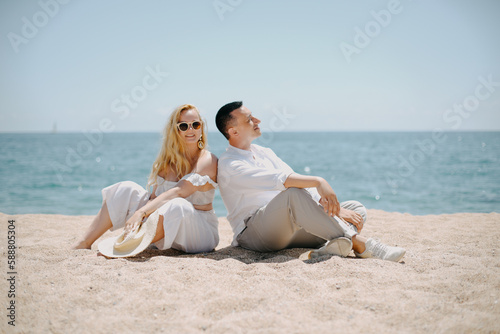 Lovers siting looking into sky and ocean, mountion, under sun. Vacation, tourism, hooneymoon. Girl with a long hair.