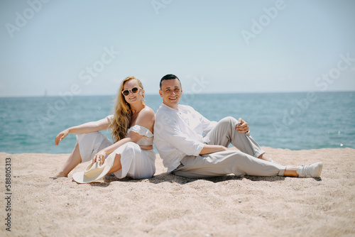 Lovers siting looking into sky and ocean, mountion, under sun.  Vacation, tourism, hooneymoon. Girl with a long hair. photo