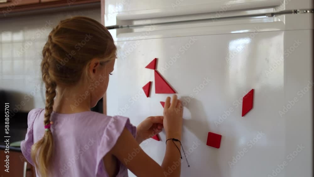 Cute little girl connecting triangles of tangram creating another shape, brain activity for a kid