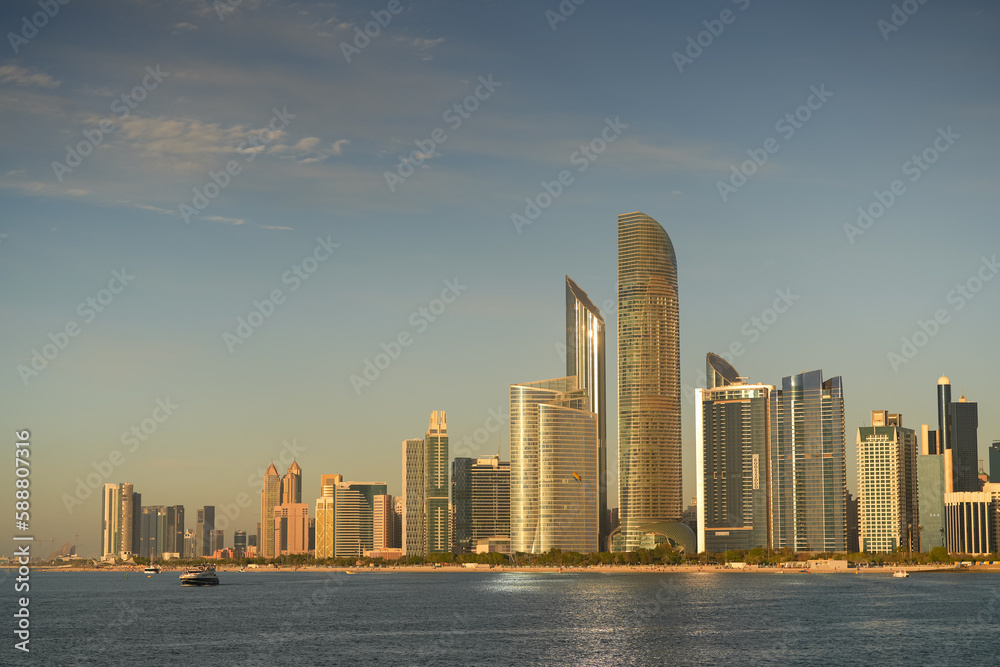 Fototapeta premium Sunset over Abu Dhabi. Landscape with skyline and skyscraper modern buildings of Abu Dhabi during a beautiful sunset. Travel to United Arab Emirates, 2023.