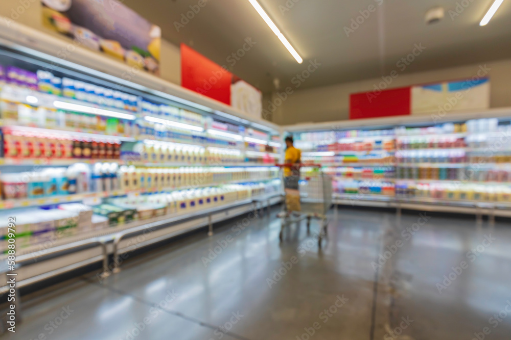 Defocused blur male of supermarket shelves with dairy products. Blur background with bokeh