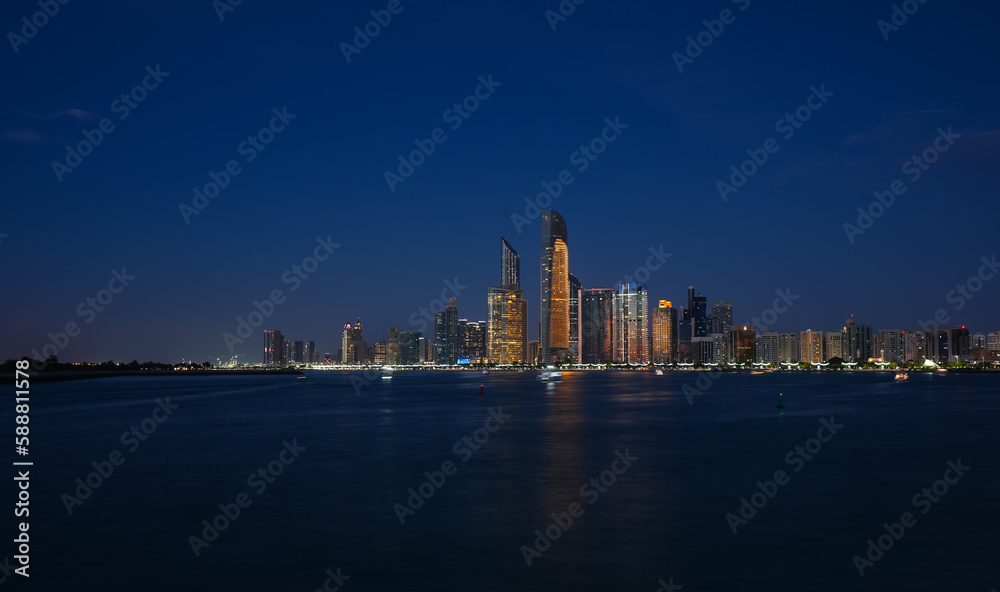 Fototapeta premium Abu Dhabi by night. Long exposure photo during the blue hour with the amazing skyline of Abu Dhabi. Travel to United Arab Emirates.